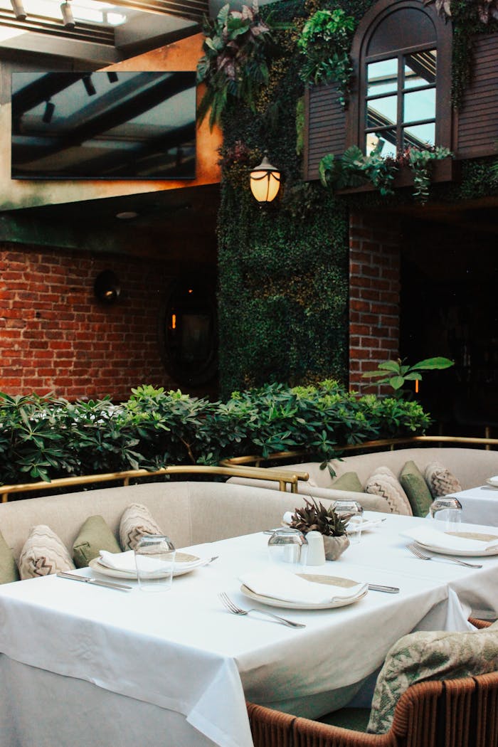 Chic outdoor dining area surrounded by lush plants and elegant decor.